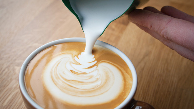 Pour milk into coffee