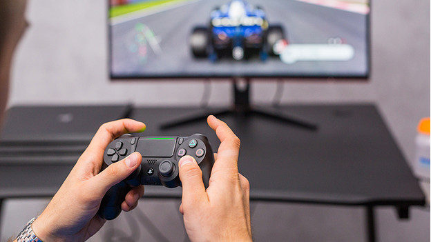 Controller van PlayStation 4 en F1 2019 op monitor. 