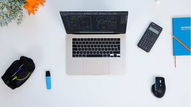 MacBook on a desk with office supplies