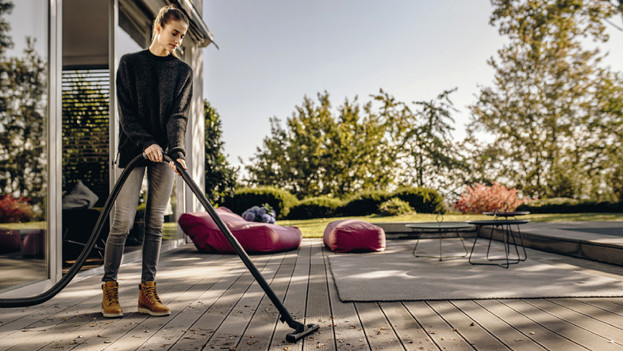 Person uses construction vacuum on patio