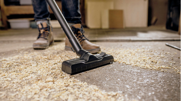 A construction vacuum vacuums sawdust