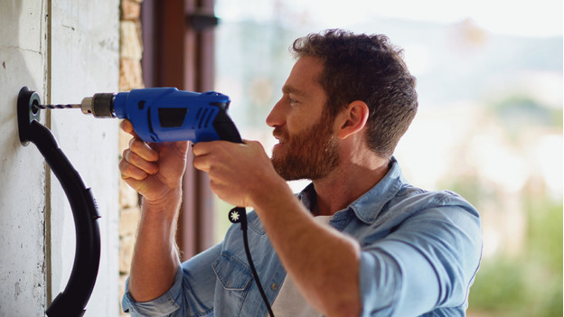 Person with drill and drill dust collector plugged into built-in socket