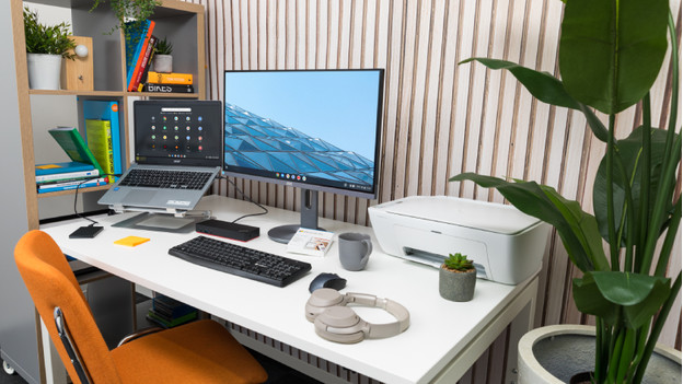 A Chromebook with a monitor on a desk.