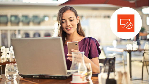 Vrouw op het terras bekijkt haar telefoon met een laptop voor zich op tafel. Een Remote Desktop logo in de rechter bovenhoek.