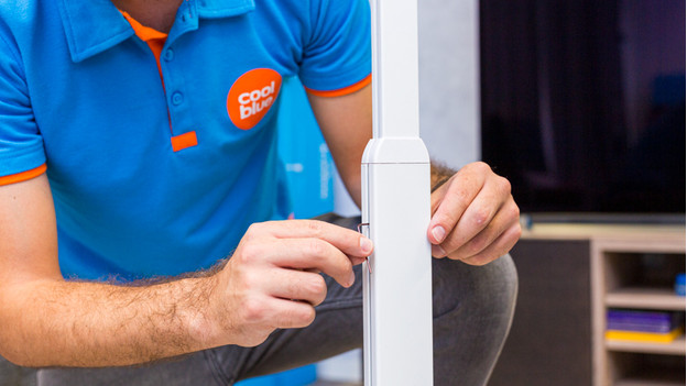 Iemand verstelt de stang van de BlueBuilt speakerstandaard