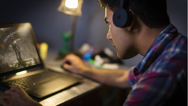 Man plays a game on a gaming laptop.