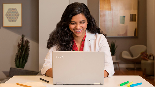 Woman laughs at what she sees on a Yoga laptop.