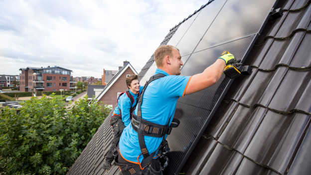 Coolblue'ers installeren zonnepanelen op een schuin dak