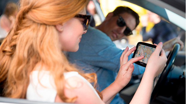 Man en vrouw met navigatiesysteem in auto