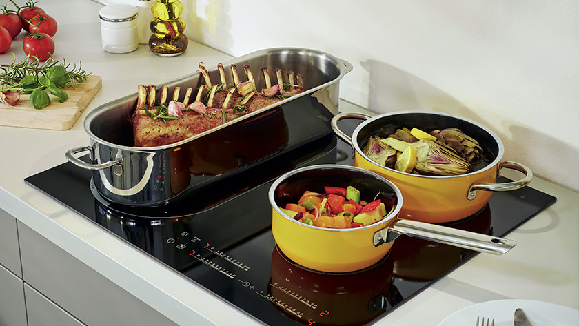 Pans with food on induction cooktop