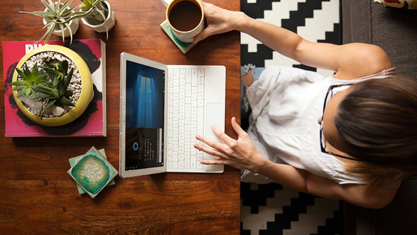 Hipster girl working behind PC in coffee bar.