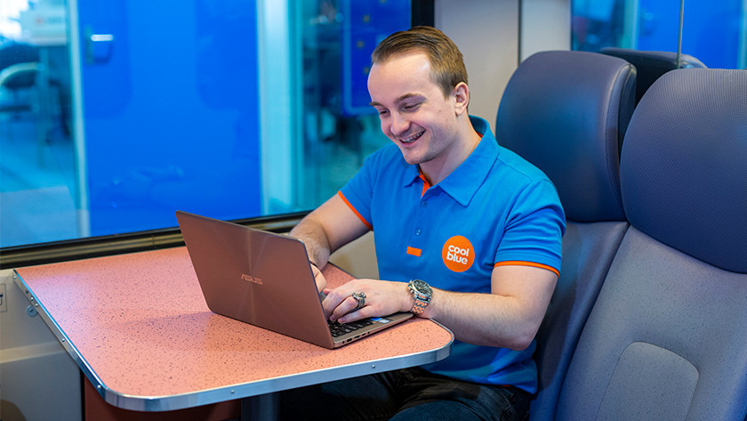 Happy person in train works on ASUS laptop.