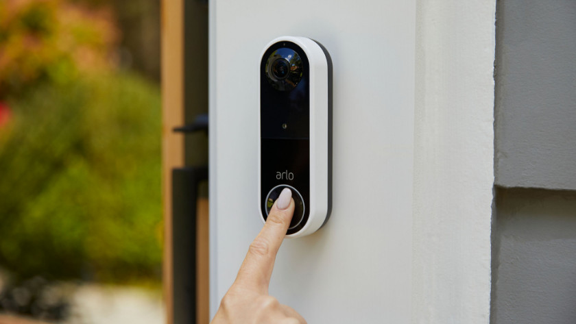 Person presses Arlo video doorbell