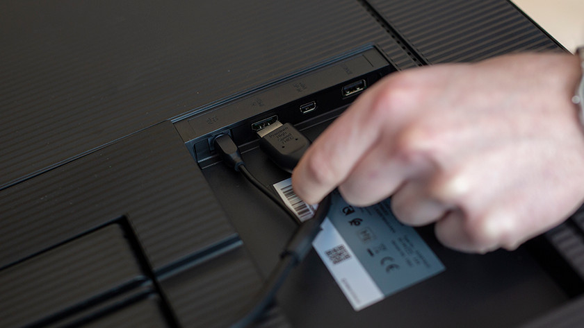 Man connecting an HDMI cable to a monitor