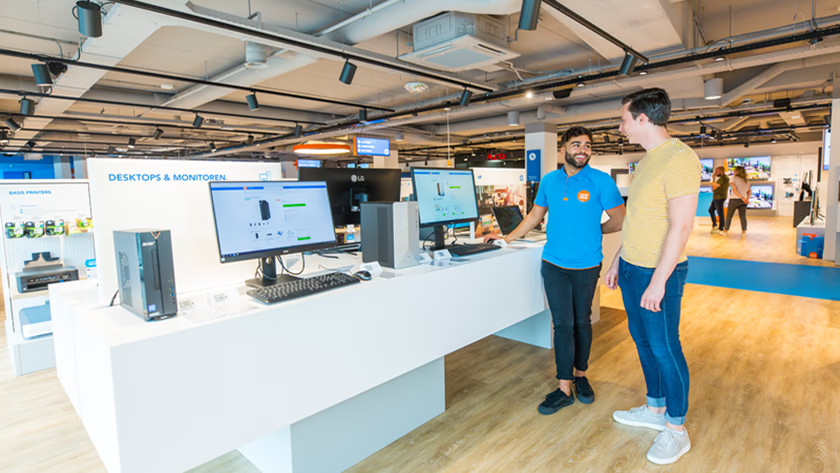 Specialist geeft advies aan een klant over het kiezen van een monitor in een winkel