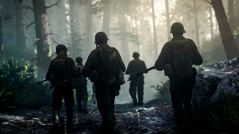 American soldiers from a World War II game walk through a forest.