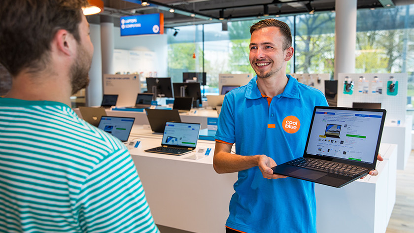 Coolblue employee showing laptop to customer in store.