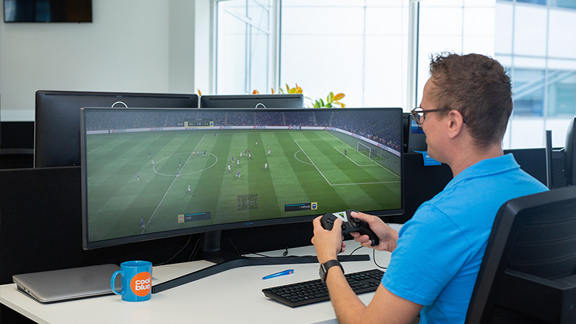 Man playing FIFA on ultrawide monitor for console gaming