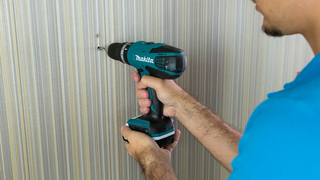 Iemand die gaten in de muurt boort