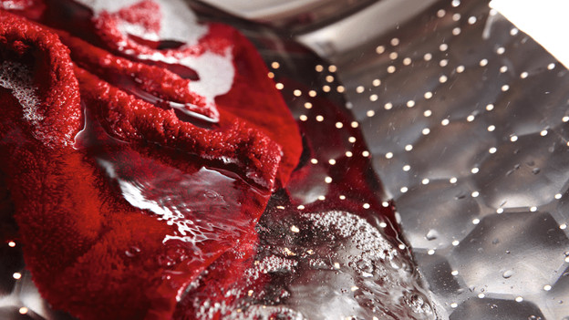 Wastrommel met wasgoed en water.