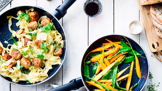 Keramische pan met pasta, gehaktballen en groenten