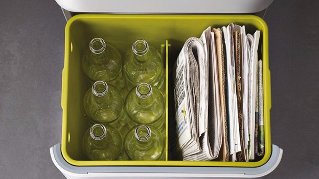 Trash can with glass and old paper
