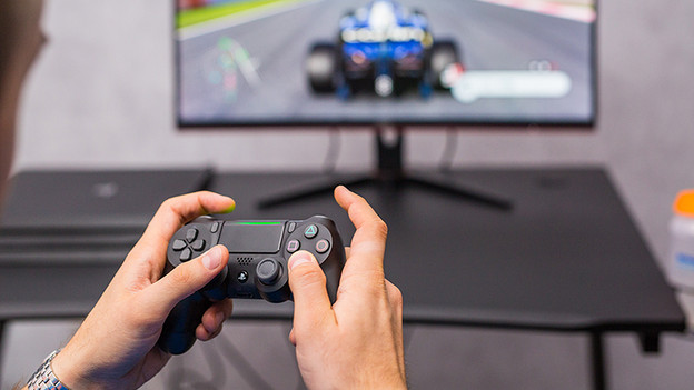 Controller van PlayStation 4 en F1 2019 op monitor. 