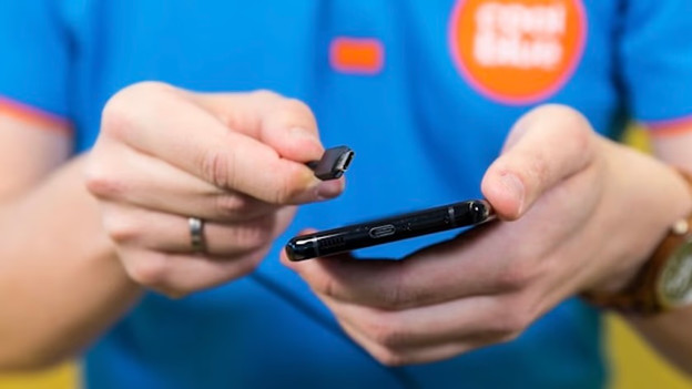 USB-C cable next to a smartphone with USB-C port