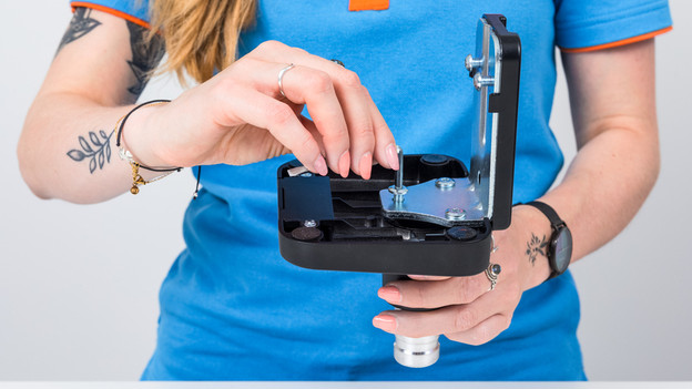 Schroef de bevestigingsplaat onder de voet.