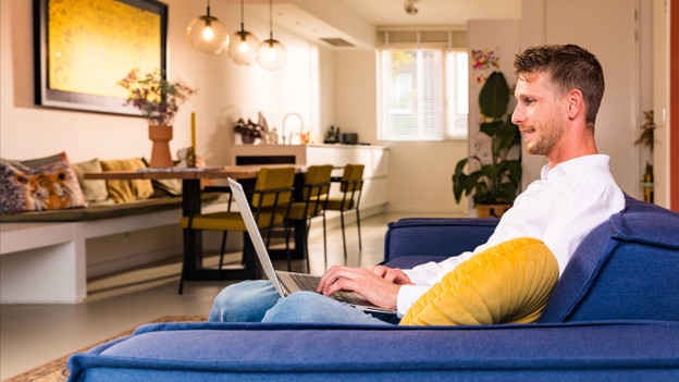 Man met laptop op schoot