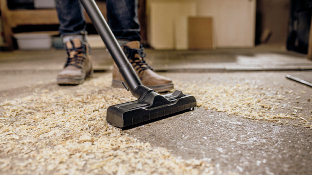 A construction vacuum vacuums sawdust