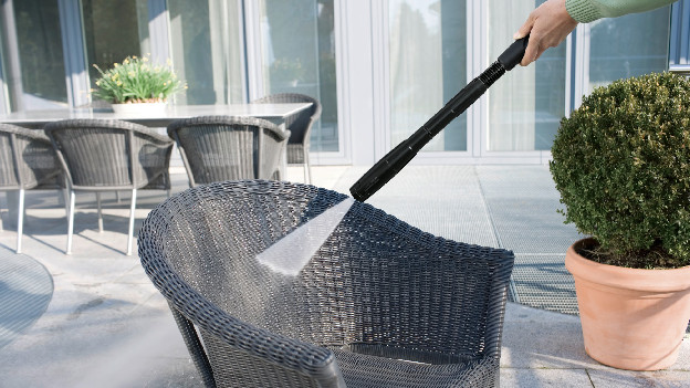 Hogedrukspuit op een tuinstoel