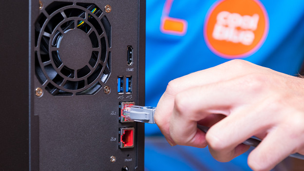Man connects NAS to the internet with an ethernet cable