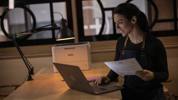 vrouw achter laptop met brother printer