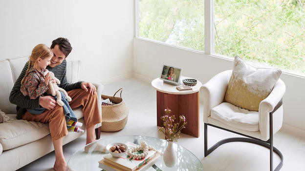 Google home hub on the table in front of family smart home