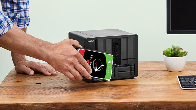 Man installeert 3,5 inch HDD in NAS