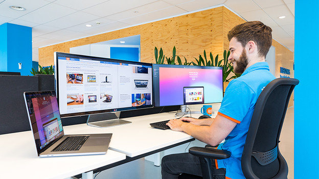 man werkt op 2 beeldschermen met macbook