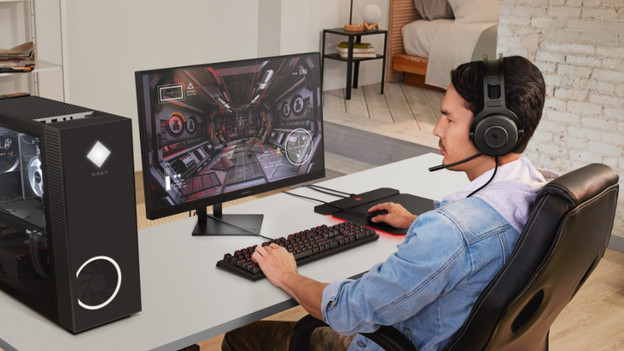 Man achter HP Omen desktop met accessoires