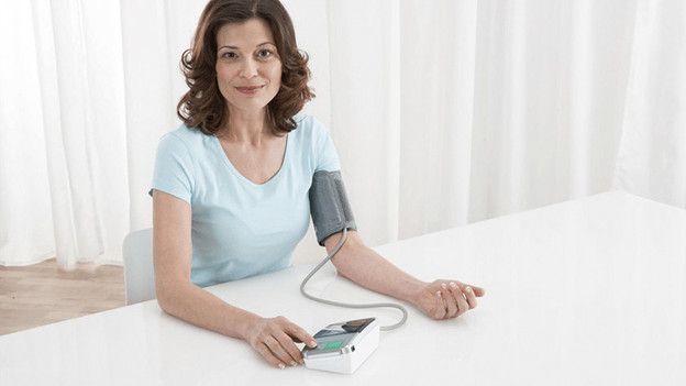 Woman with blood pressure monitor