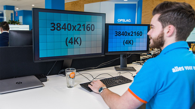 Man works at desk on screen with 4K resolution.
