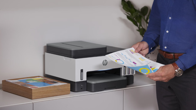Man haalt papier uit een printer