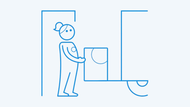 Zakenman werkt op laptop terwijl er een notitieboek op tafel naast hem ligt. 