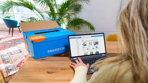 Person unboxes Second Chance laptop on des