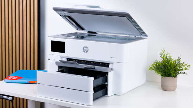 Grote printer met openstaande papierlades en klep