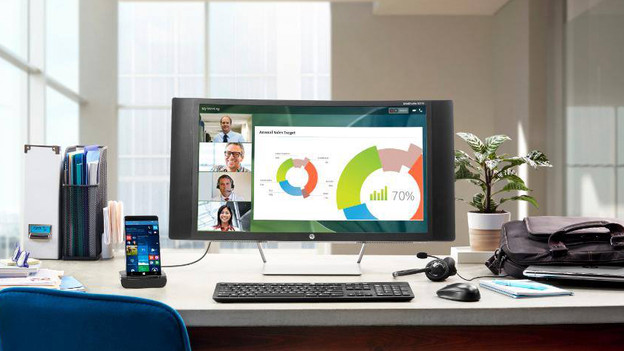 Computer on a desk with accessories around it.