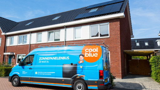 Coolblue bus naast een huis met zonnepanelen